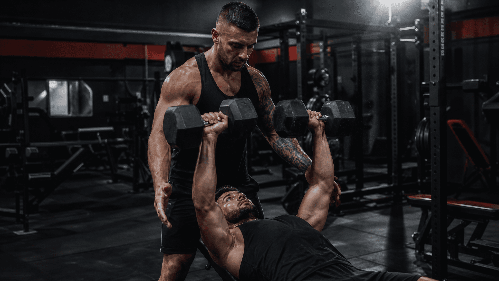 Fitness coach spotting a client through a heavy deadlift